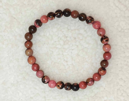 Pierre : Rhodonite - Qualité : AB - Origine : Brésil Taille de perle : 6mm - Forme : Boule Le produit que tu recevras peut différer de la photo de présentation, car chaque pierre naturelle est unique !