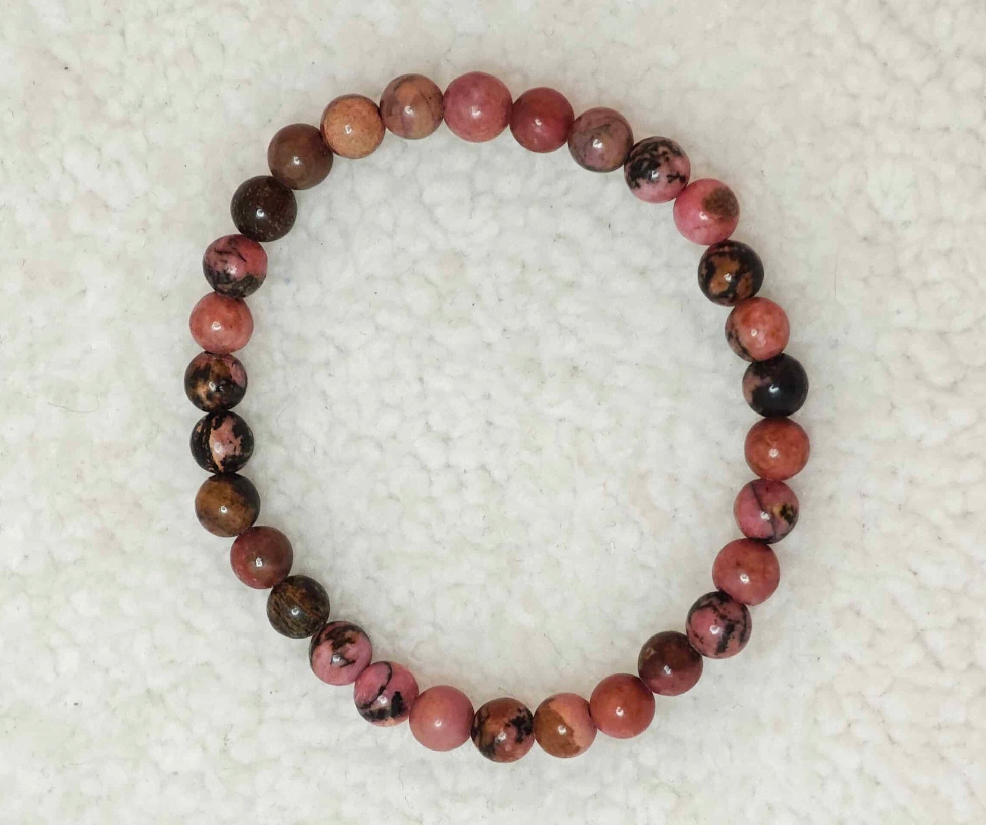 Pierre : Rhodonite - Qualité : AB - Origine : Brésil Taille de perle : 6mm - Forme : Boule Le produit que tu recevras peut différer de la photo de présentation, car chaque pierre naturelle est unique !